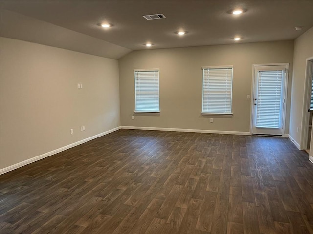 empty room with vaulted ceiling and dark wood-type flooring