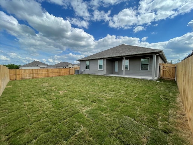 back of property with a patio area, central AC unit, and a lawn