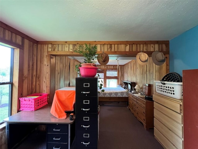 bedroom with carpet, a textured ceiling, and wood walls