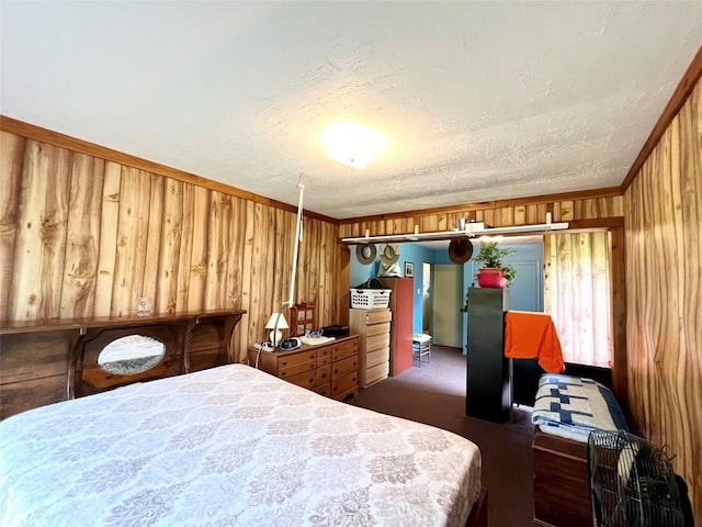 carpeted bedroom featuring crown molding, a textured ceiling, and wood walls