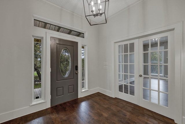 entryway with ornamental molding, dark wood-type flooring, an inviting chandelier, and french doors