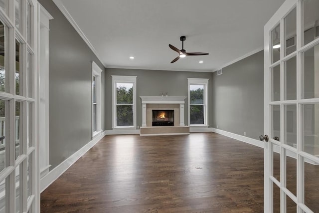 unfurnished living room with dark hardwood / wood-style flooring, crown molding, french doors, and a healthy amount of sunlight