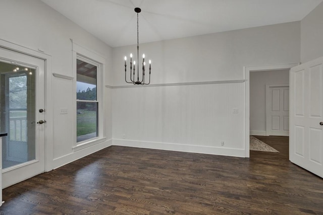 unfurnished dining area with dark hardwood / wood-style floors and a chandelier