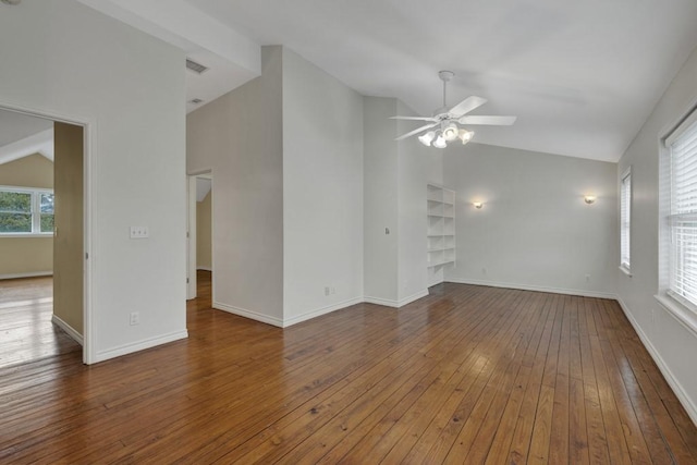 unfurnished living room with hardwood / wood-style flooring, ceiling fan, built in shelves, and vaulted ceiling