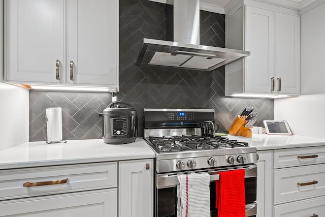 kitchen featuring white cabinetry, stainless steel range with gas cooktop, tasteful backsplash, and wall chimney range hood