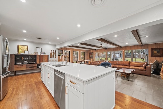 kitchen featuring sink, light hardwood / wood-style flooring, a kitchen island with sink, white cabinetry, and stainless steel appliances