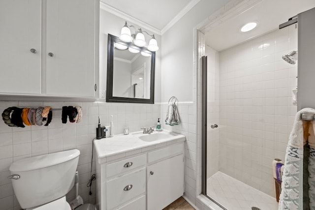 bathroom with tile walls, vanity, an enclosed shower, toilet, and crown molding