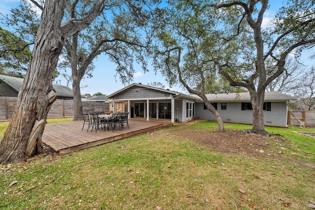 back of house with a deck and a lawn