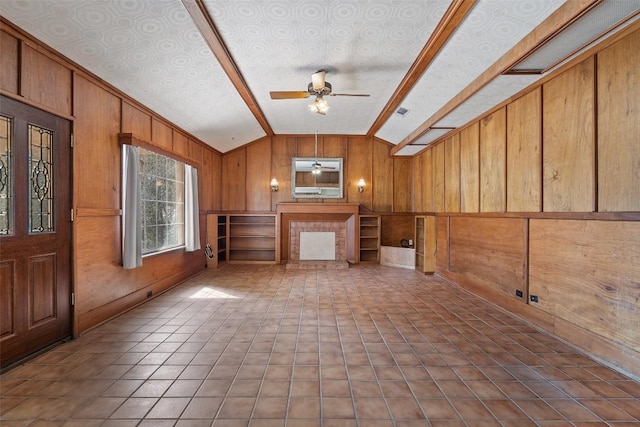 unfurnished living room with ceiling fan, tile patterned flooring, vaulted ceiling, and wood walls