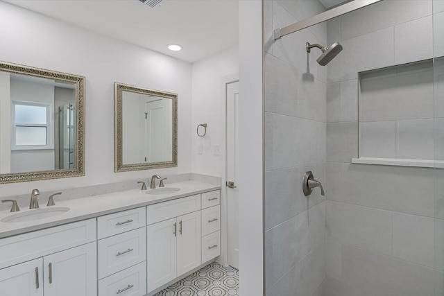 bathroom with tiled shower and vanity