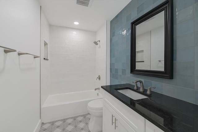 full bathroom with tile walls, vanity, toilet, and tiled shower / bath