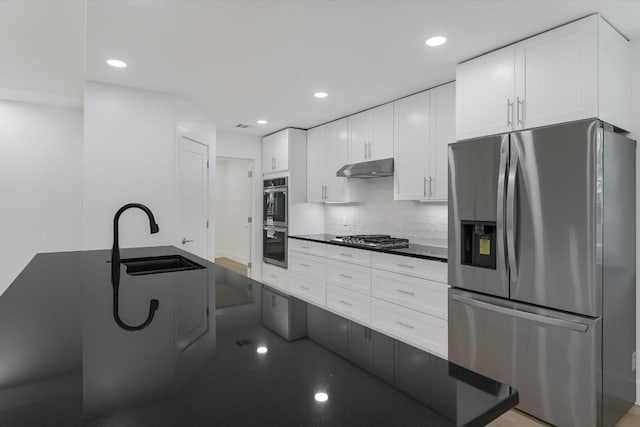 kitchen featuring sink, decorative backsplash, white cabinets, and appliances with stainless steel finishes