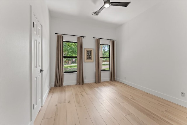 empty room with visible vents, ceiling fan, light wood-style flooring, and baseboards