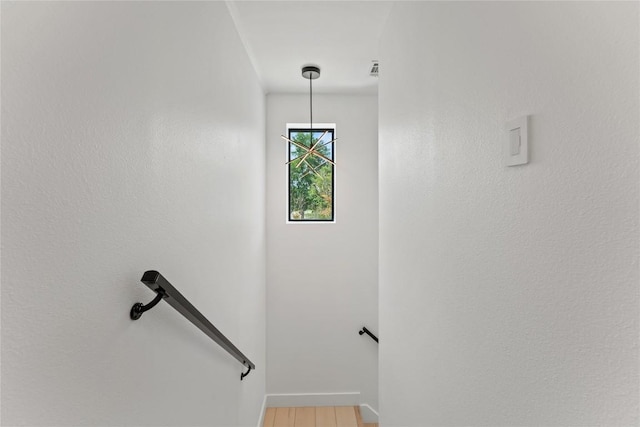 stairs featuring wood finished floors, visible vents, and baseboards