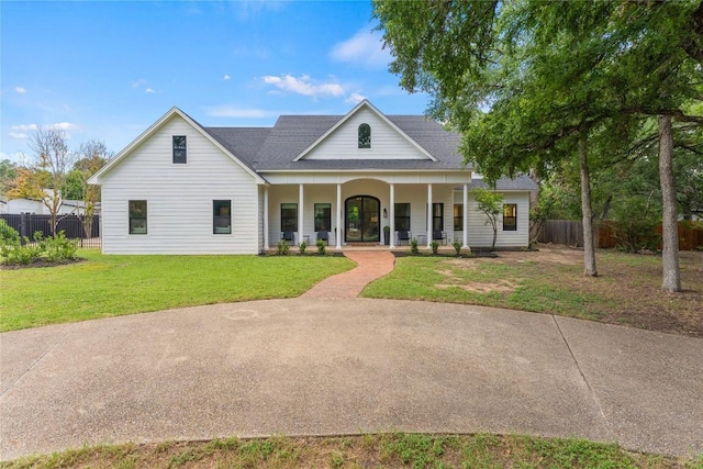 view of front facade featuring a front yard, fence, and covered porch