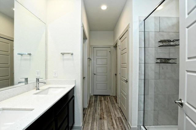 bathroom featuring vanity, hardwood / wood-style floors, and a shower with shower door