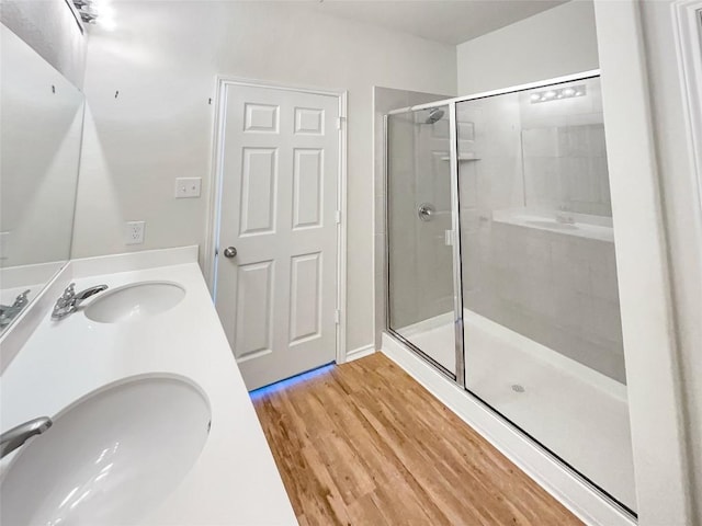 bathroom with wood-type flooring, vanity, and a shower with shower door