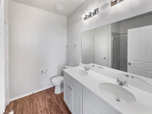 bathroom with walk in shower, vanity, toilet, and hardwood / wood-style floors