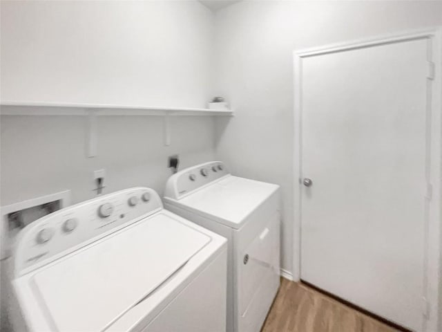 laundry room featuring washing machine and dryer and light wood-type flooring