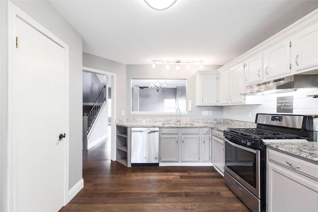 kitchen with dark wood-type flooring, sink, white cabinetry, light stone counters, and stainless steel appliances