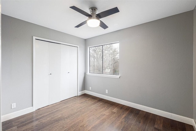 unfurnished bedroom with wood-type flooring, ceiling fan, and a closet