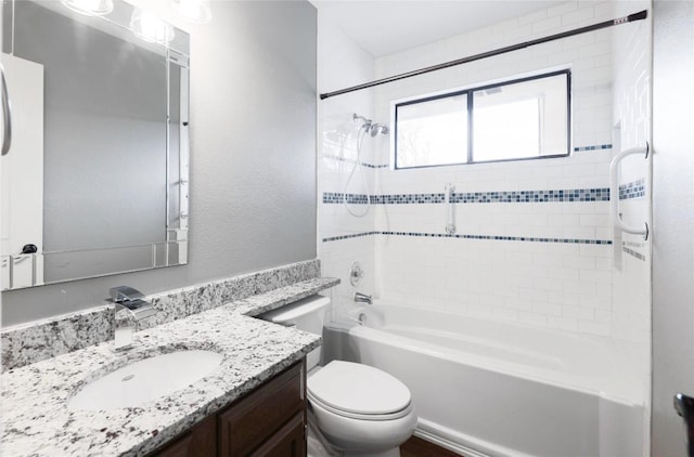 full bathroom featuring tiled shower / bath, vanity, and toilet