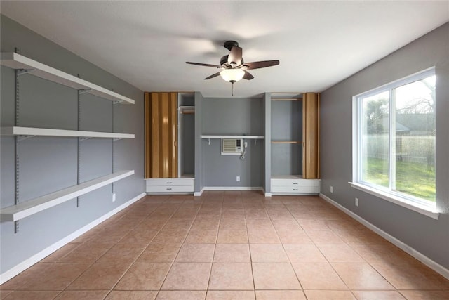 unfurnished room featuring ceiling fan, tile patterned floors, and an AC wall unit