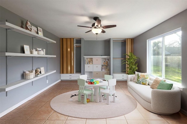 sitting room with tile patterned floors and ceiling fan