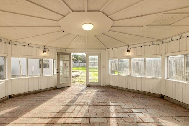 unfurnished sunroom featuring vaulted ceiling