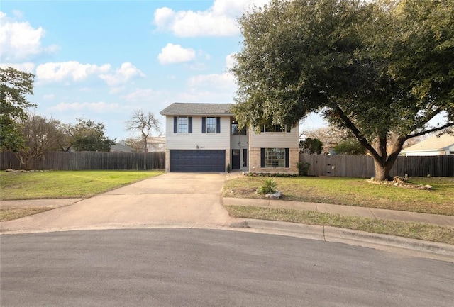 bi-level home featuring a garage and a front lawn