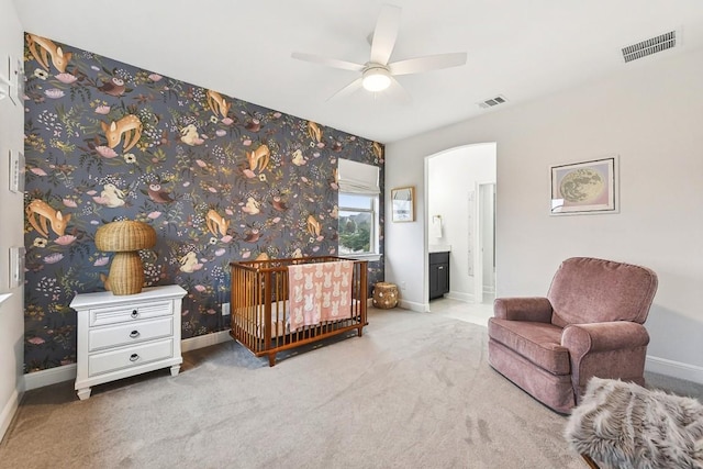 carpeted bedroom with ensuite bath and ceiling fan