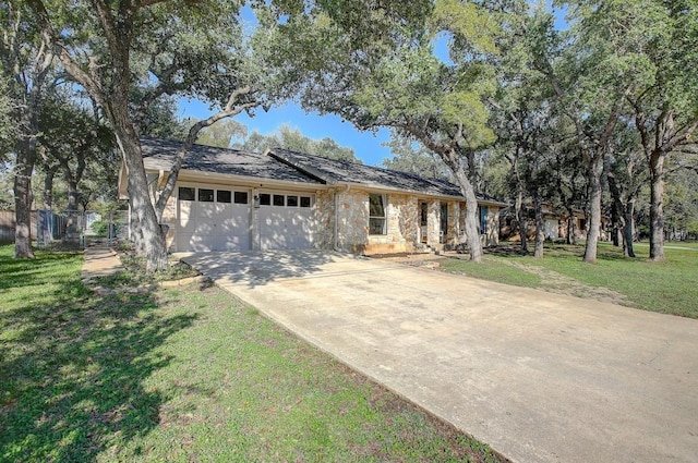 single story home with a front lawn, fence, concrete driveway, a garage, and stone siding