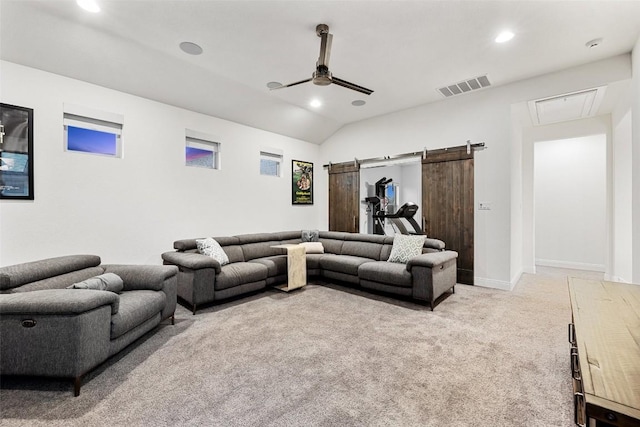 cinema room featuring vaulted ceiling, a barn door, light colored carpet, and ceiling fan