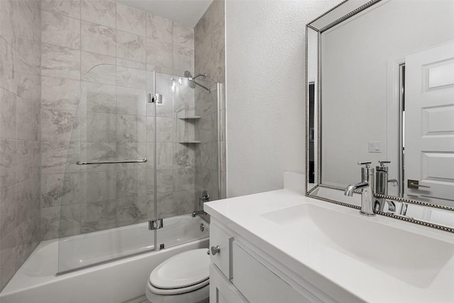 full bathroom with enclosed tub / shower combo, vanity, and toilet