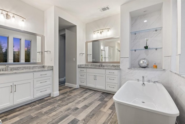 bathroom with vanity, hardwood / wood-style floors, and a tub