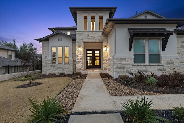 exterior entry at dusk featuring french doors