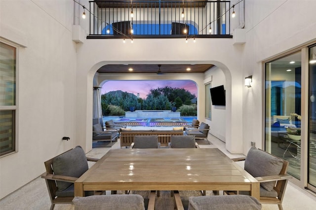 view of patio with a pool and a balcony