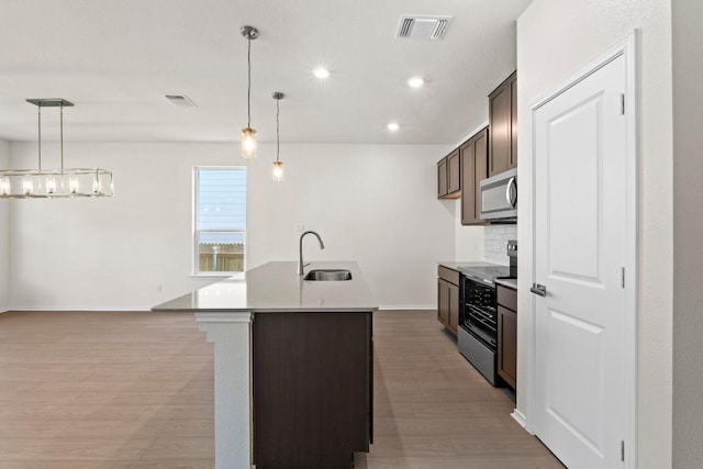 19216 Lady Bird Johnson St, Manor, TX 78653 - kitchen with electric range oven, stainless steel microwave, light wood-type flooring, recessed lighting, and light countertops