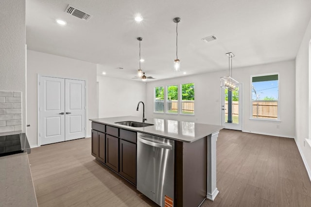 19216 Lady Bird Johnson St, Manor, TX 78653 - kitchen featuring dishwasher, light wood finished floors, light countertops, open floor plan, and pendant lighting