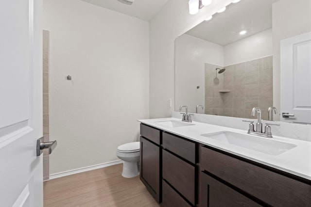 19216 Lady Bird Johnson St, Manor, TX 78653 - full bathroom featuring wood finished floors, double vanity, and tiled shower