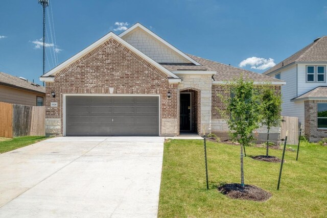 19216 Lady Bird Johnson St, Manor, TX 78653 - traditional home with brick siding, a garage, driveway, and roof with shingles