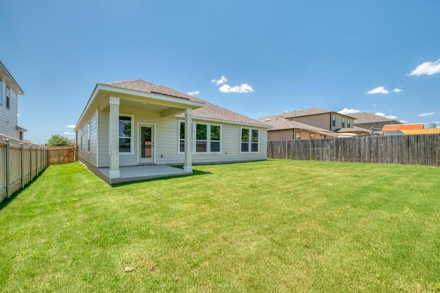 19216 Lady Bird Johnson St, Manor, TX 78653 - back of property featuring a fenced backyard, a patio, and a shingled roof