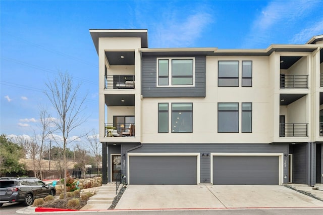 2050 Lohmans Spur Rd Unit 101, Lakeway, TX 78734 - view of property featuring a balcony, an attached garage, stucco siding, and driveway
