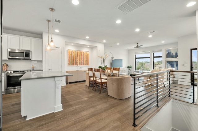2050 Lohmans Spur Rd Unit 101, Lakeway, TX 78734 - kitchen featuring visible vents, appliances with stainless steel finishes, a center island, dark wood finished floors, and open floor plan