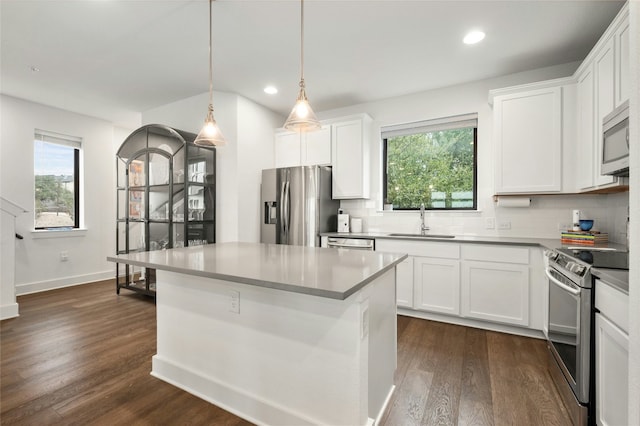 kitchen featuring pendant lighting, sink, white cabinets, and appliances with stainless steel finishes