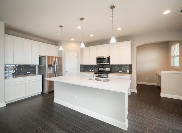 237 Andele Way, Liberty Hill, TX 78642 - kitchen featuring appliances with stainless steel finishes, arched walkways, decorative backsplash, light countertops, and recessed lighting