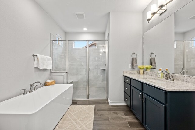 bathroom featuring wood-type flooring, vanity, and plus walk in shower