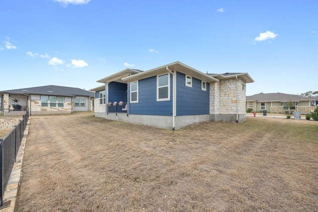 view of front facade with stone siding and fence