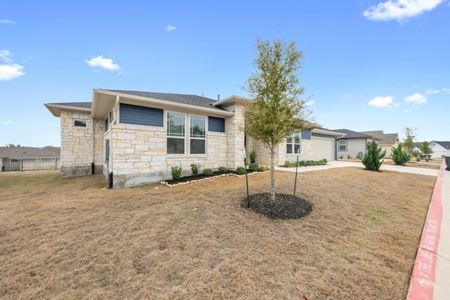 view of front facade featuring driveway, a front lawn, an attached garage, and fence