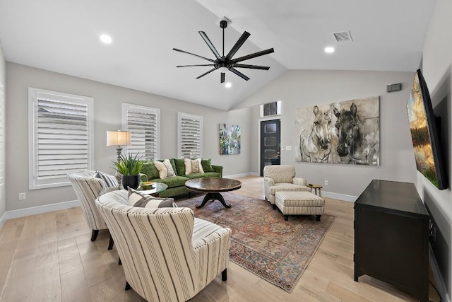 living room featuring lofted ceiling and light hardwood / wood-style flooring